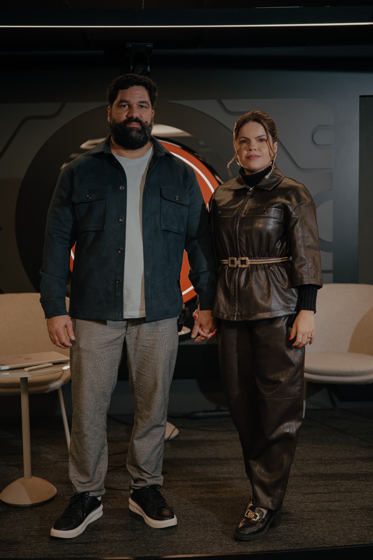 Luana Dias e Webert Gaiofato em um palco durante uma apresentação para empresários.